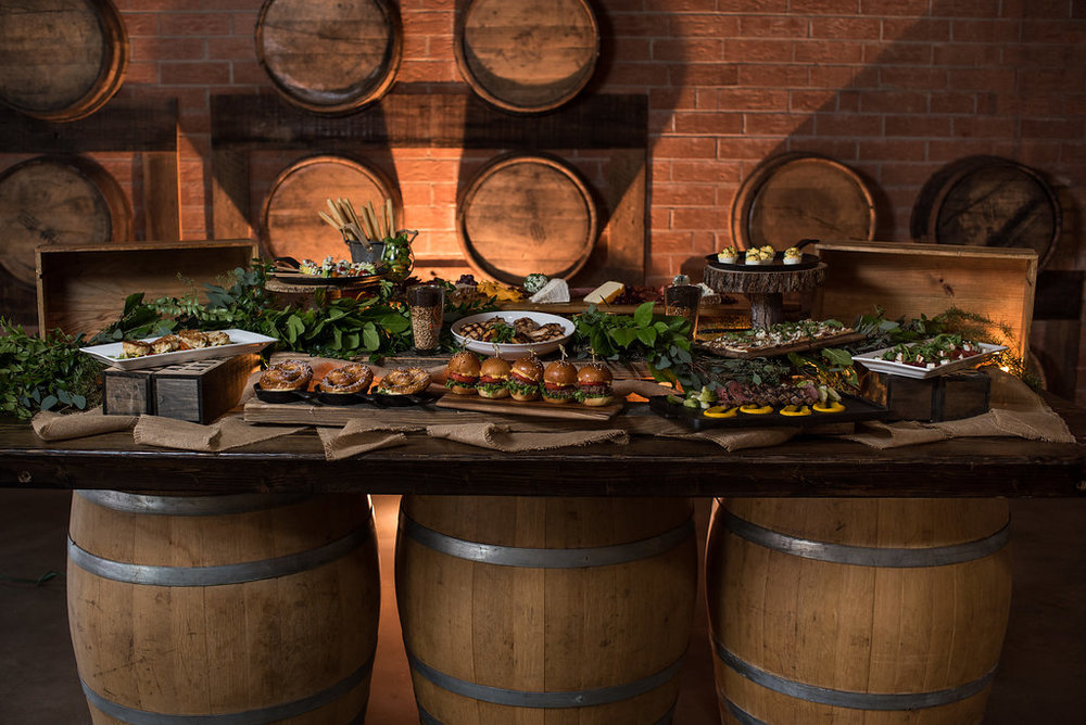 Detail shot of spread of  food on barrels, part of a Boho Brewery Wedding Styled Shoot at Triple C Barrel Room in Charlotte NC. Farmhouse Table, setting, and food provided by Best Impressions Caterers and Party Reflections.