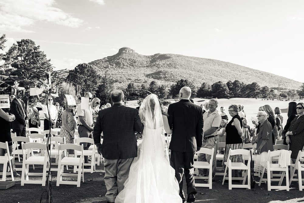 Black and White of Bride getting walked down aisle at Pilot Knob Country Club. Wedding Photography by Party of Two Photography.