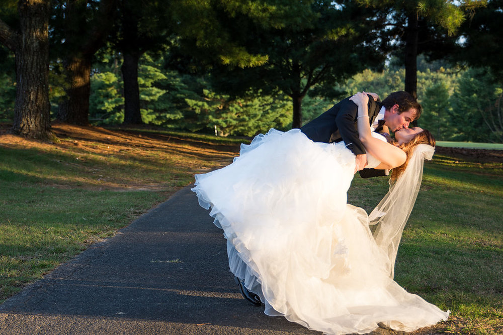 Groom dips Bride for Sunset Portrait at Pilot Knob Country Club. Wedding Photography by Party of Two Photography.