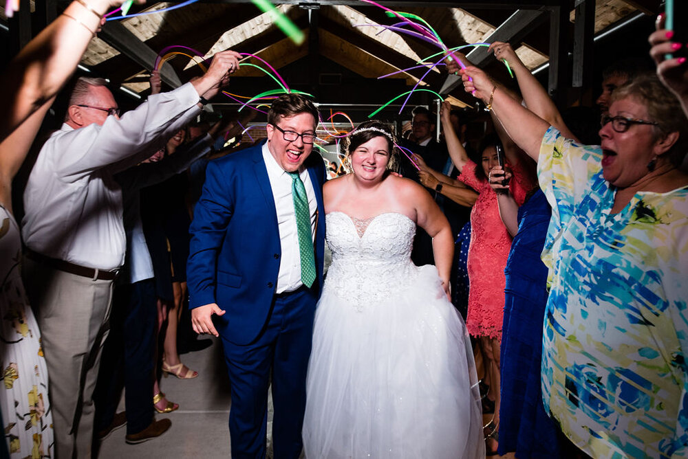 Bride and groom glow stick exit at Campbell Lodge Reception, Durant Nature Preserve, Raleigh wedding by Charlotte Wedding Photographers