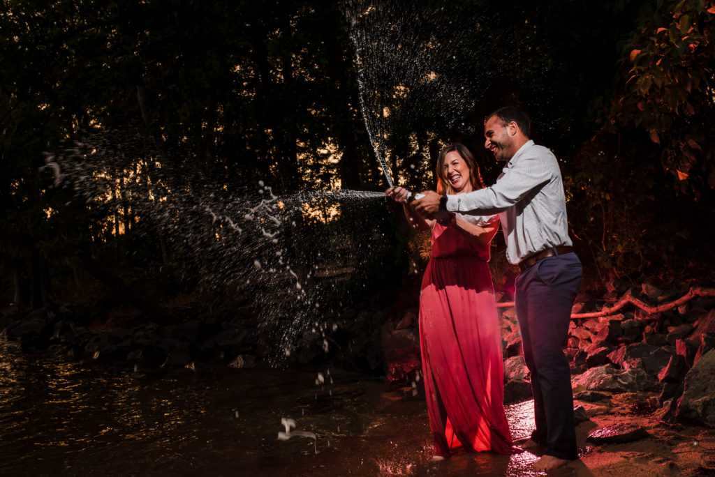 Popping champagne for engagement photos at Jetton Park in Charlotte NC