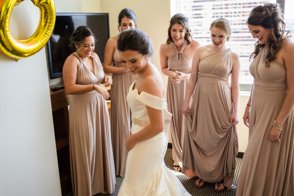 Bridesmaids seeing bride for first time in Uptown Charlotte Hotel Room