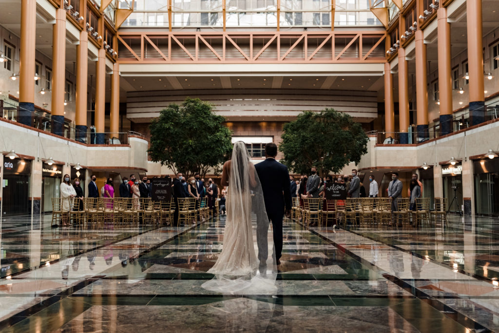 Bride walking down aisle during rainy day at Founders Hall