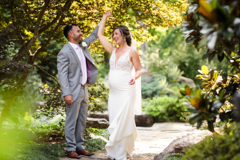 Bride and Groom twirling at UNCC Botanical Gardens Wedding Portraits