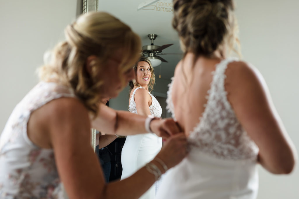 Bride getting dressed with mother at home