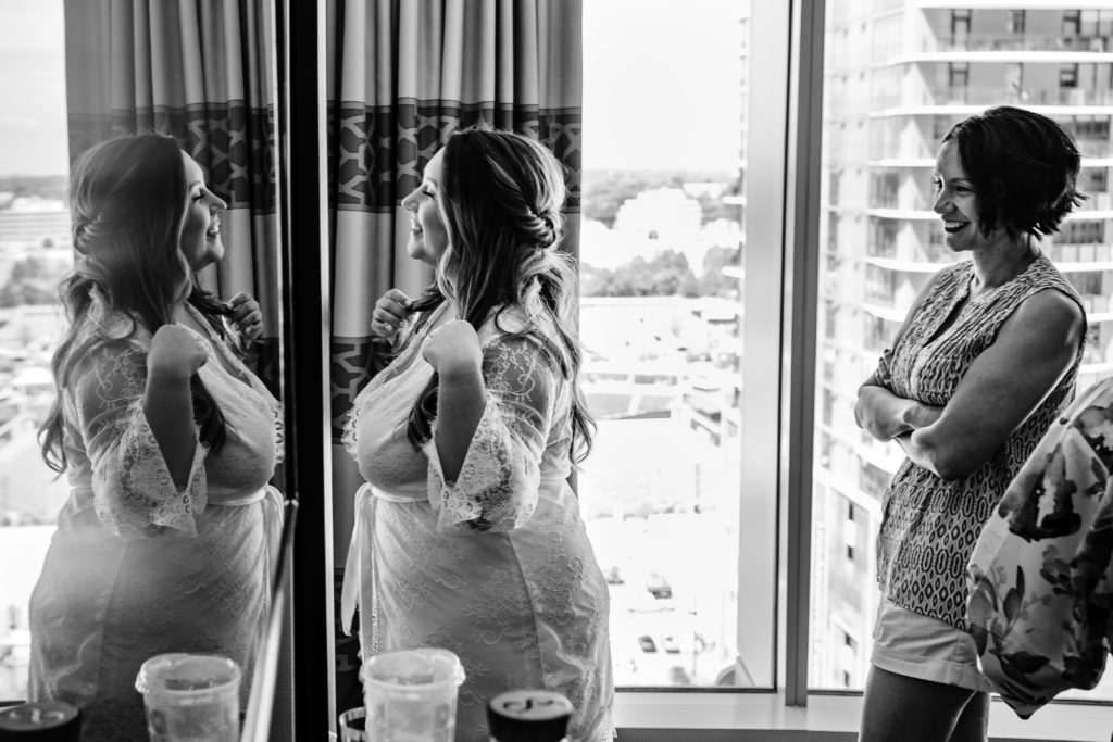 Bride getting ready in mirror at Kimpton Park Tryon hotel in Charlotte NC