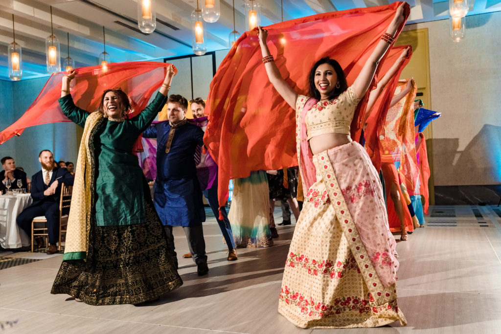 Friends and Family perform for guests for colorful summer Indian Wedding