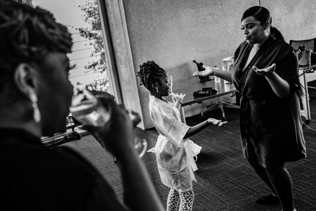 Flower girl and bridesmaid interacting before a wedding