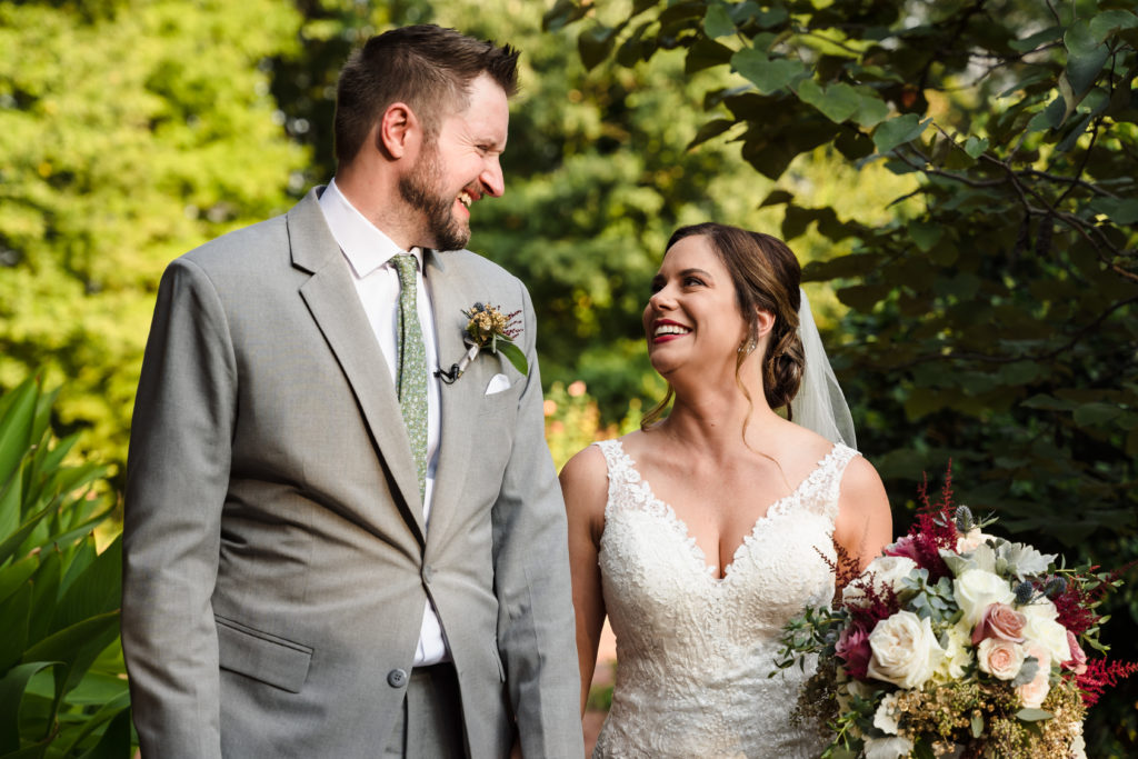 Megan and Mickey smile at each other during their outdoor wedding portraits at Alexander Homestead.