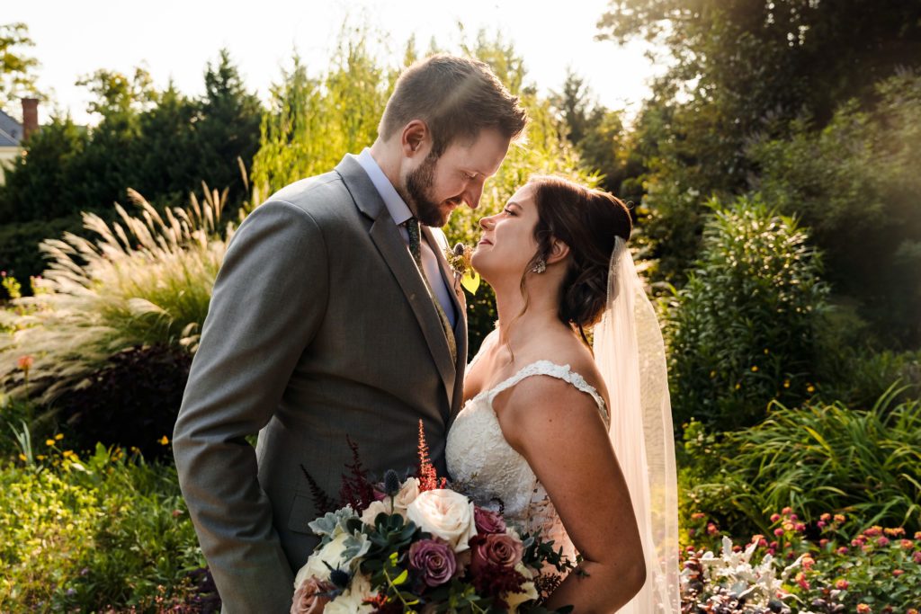 Megan and Mickey look into each other's eyes in front of the beautiful garden at Alexander Homestead for their wedding.