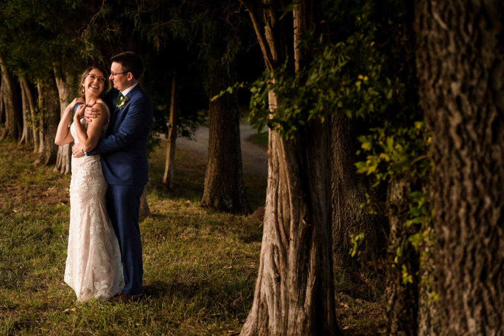 Golden Light farm wedding portrait against trees at Rural Hill in North Carolina.