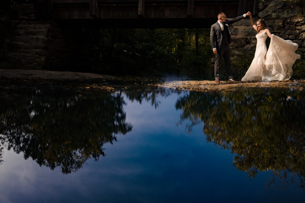 Groom spinning bride with sunny reflection at Vesuvius Vineyards near Charlotte North Carolina