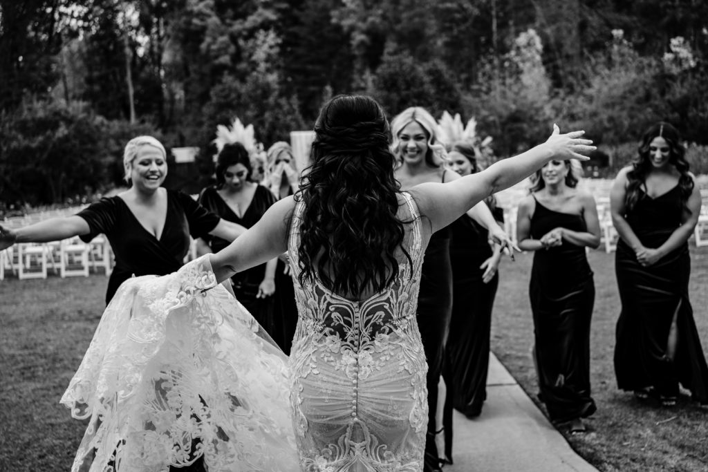 Bride shows off dress to bridesmaids excited reaction on the lawn of Sweet Magnolia Estate