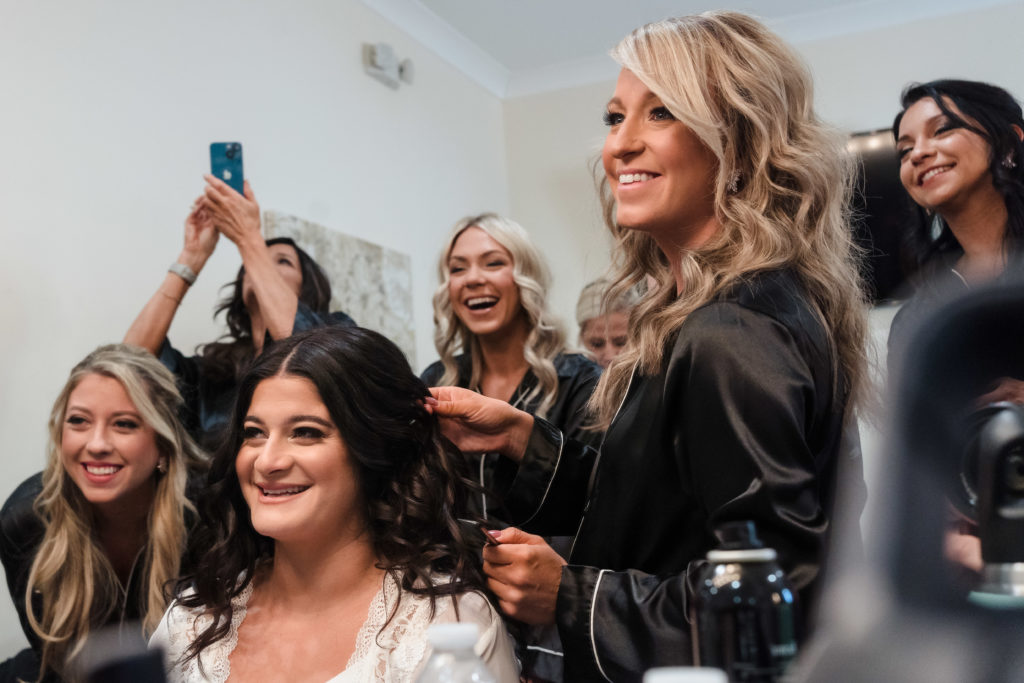 Bride and bridal party takes mirror selfie in getting ready room of Sweet Magnolia Estate