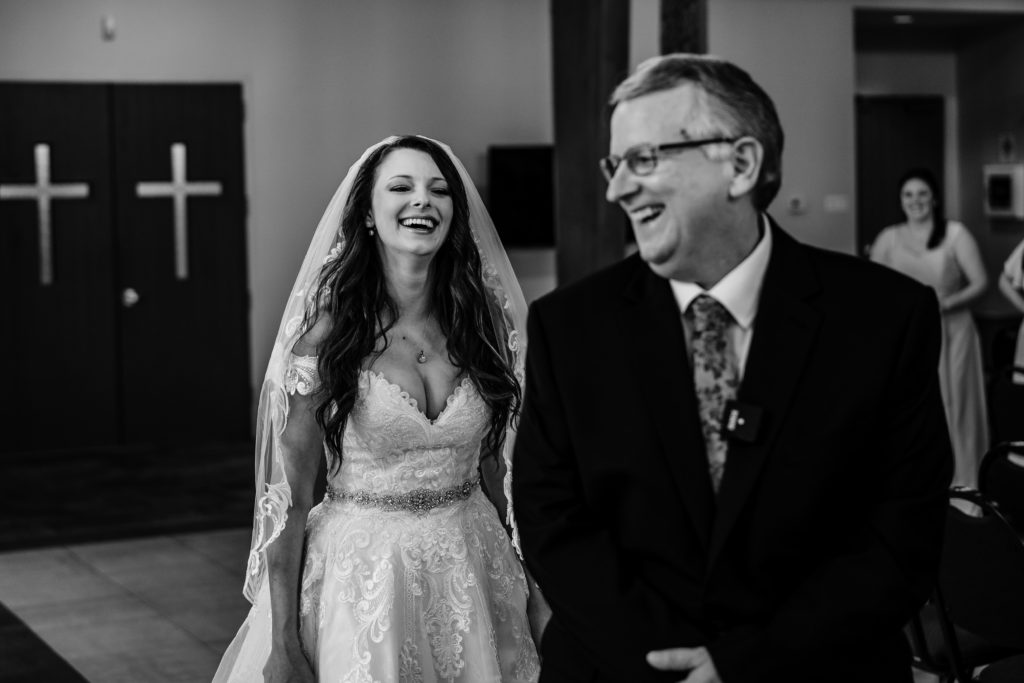 Bride sees father during a sweet first look in a catholic church in Winston Salem