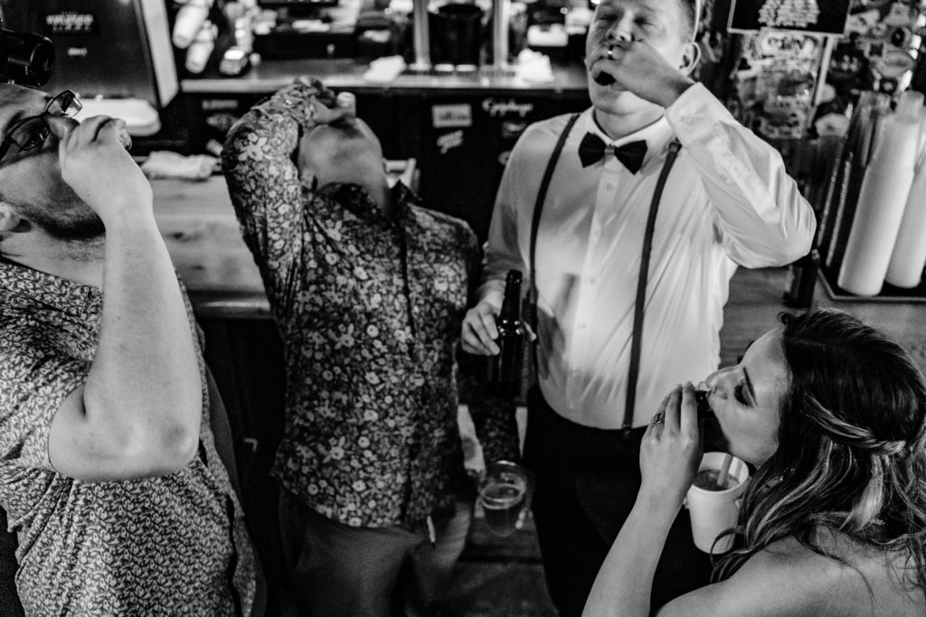 wedding couple and friends taking shots while bar hopping