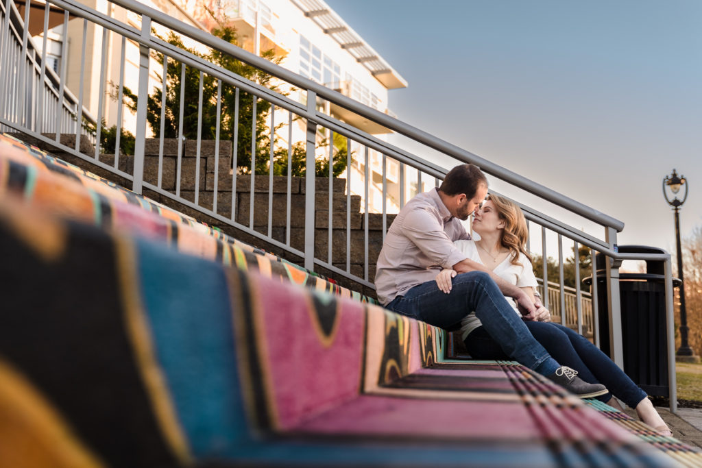 Couple seated on steps for Colorful Charlotte engagement session