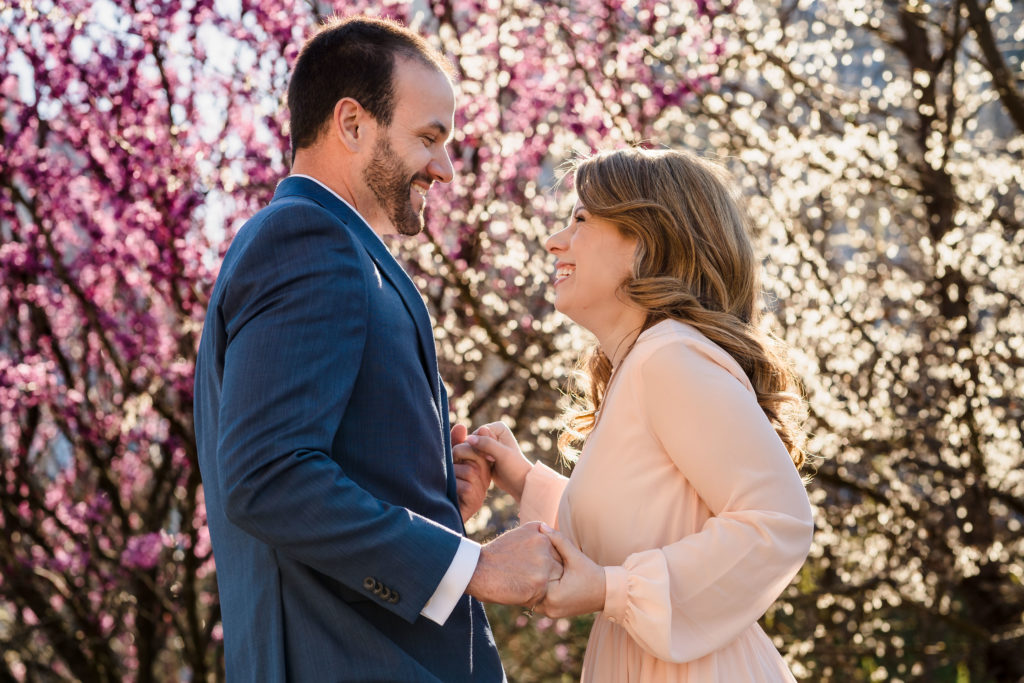 pink trees behind smiling couple during Colorful Charlotte engagement session