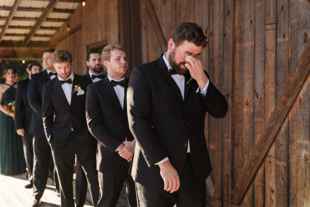 Emotional Groom right before wedding ceremony outside barn at Venues at Langtree