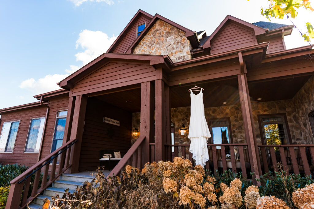 Fall wedding at Mountain House Inn with wedding dress hanging over porch