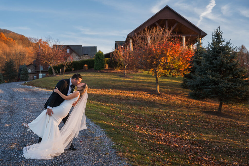 Newlyweds dip portrait at Mountain House Inn surrounded by fall foliage