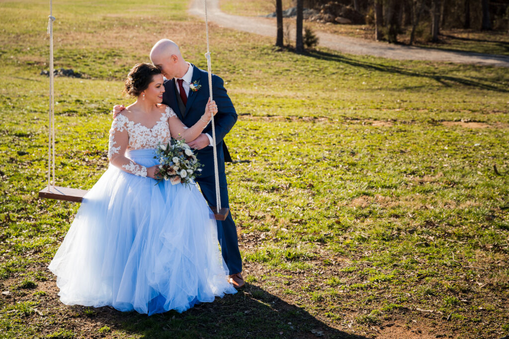 Bride and Groom wedding portraits outside in winter on tree swing at Pleasant Grove Farm