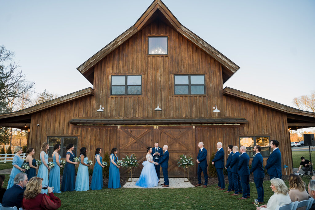 Outdoor informal wedding ceremony at Pleasant Grove Farm standing in front of barn venue