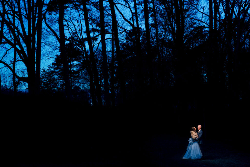 Bride and Groom in Winter wedding portrait standing outside during blue hour in the middle of a forest