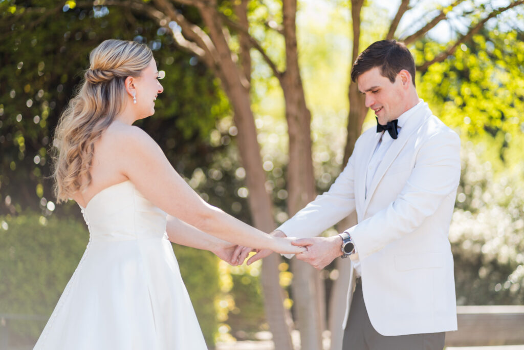 Bride and Groom dressed in white see each other for a first look before the wedding during spring in Charlotte