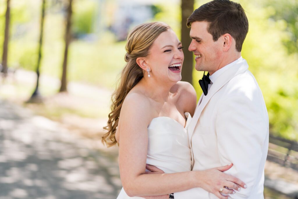 Bride and Groom dressed in white see each other for a first look at Pearl Park in Charlotte before the wedding during spring