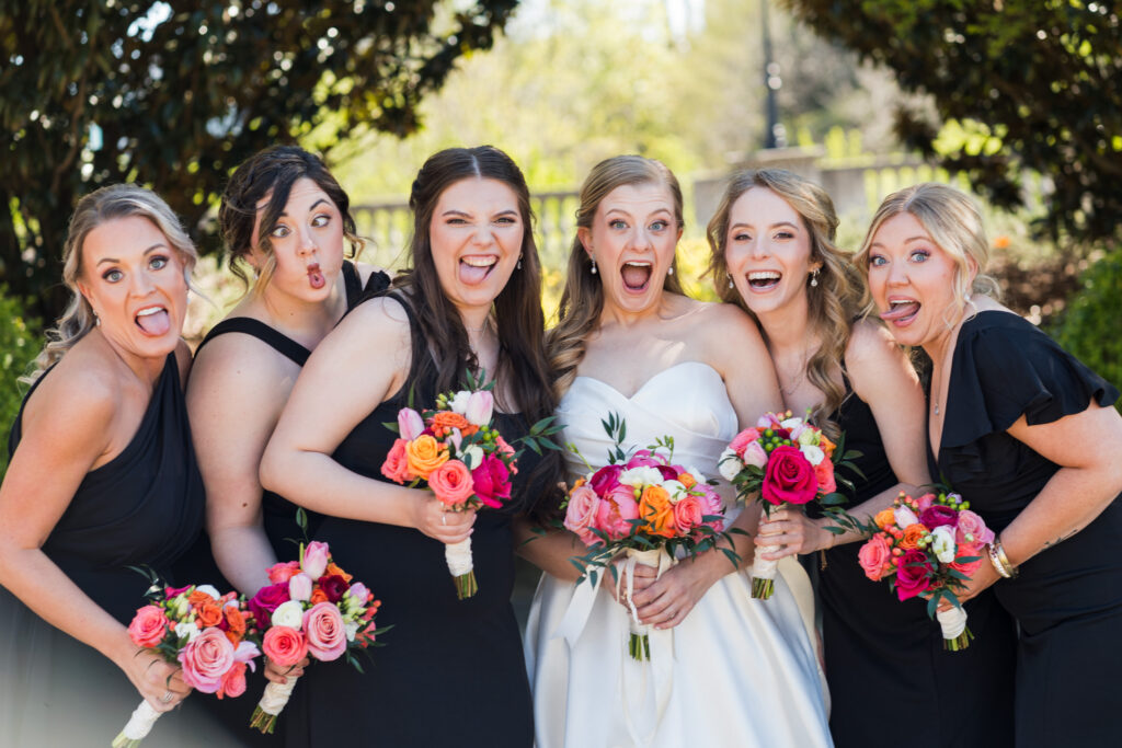 Bride and Bridesmaids have silly faces at Pearl Park in Charlotte before the wedding during spring