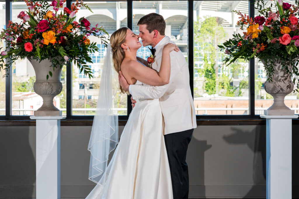 Bride and Groom share first kiss for their wedding surrounded by Spring flowers at Terrace at Cedar Hill Venue in Charlotte