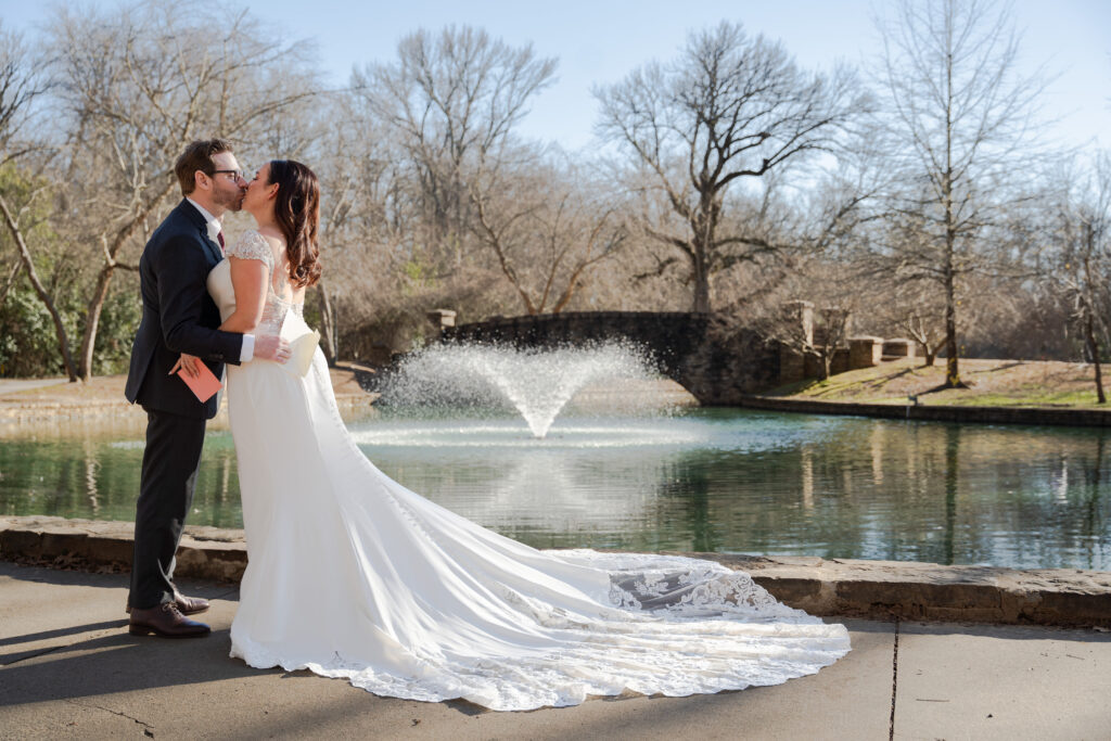 Bride and Groom kissing in front of fountain in winter at Freedom Park in Charlotte North Carolina