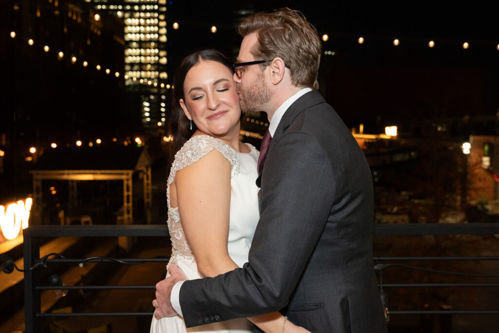 Groom kissing bride with Charlotte in background on New Years Eve